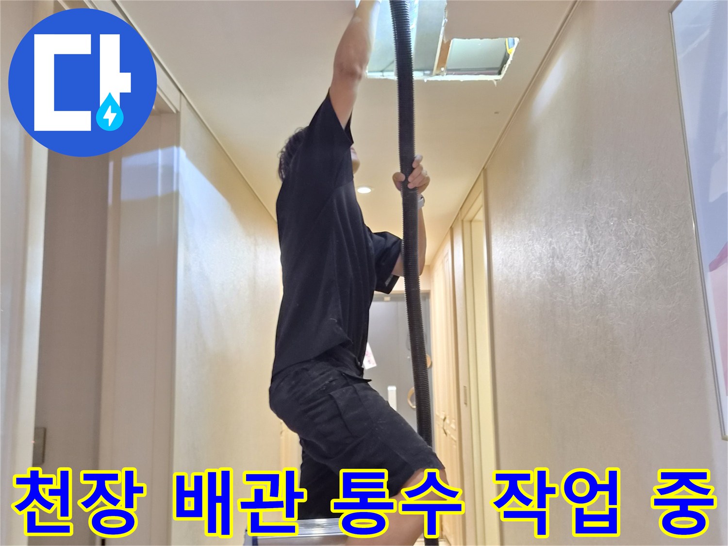 사다리 위에서-천장 점검구를 통해-배관 내부 이물질을 제거하는 모습