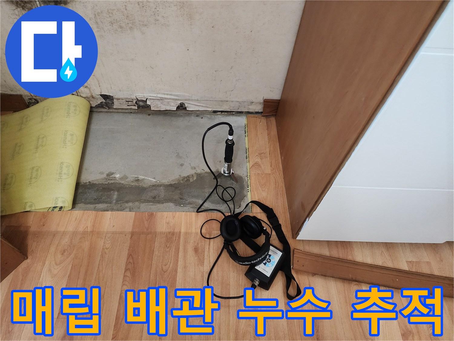 바닥 면에 청음식 탐지기를 사용하여 누수를 찾는 작업 장면