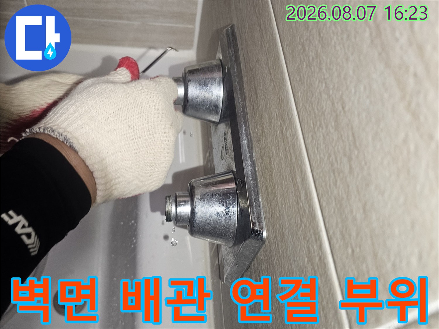 타일 벽면에 설치된-금속 배관 부속의 근접 촬영 사진
