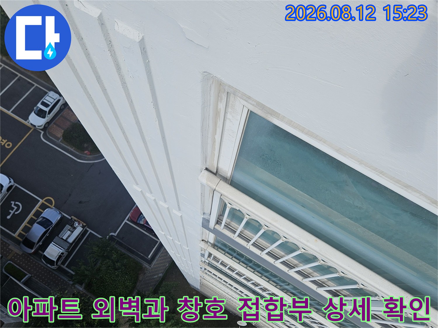 고층 건물의 흰색 외벽 도장면과 유리창 프레임 연결부를 위에서 내려다본 사진