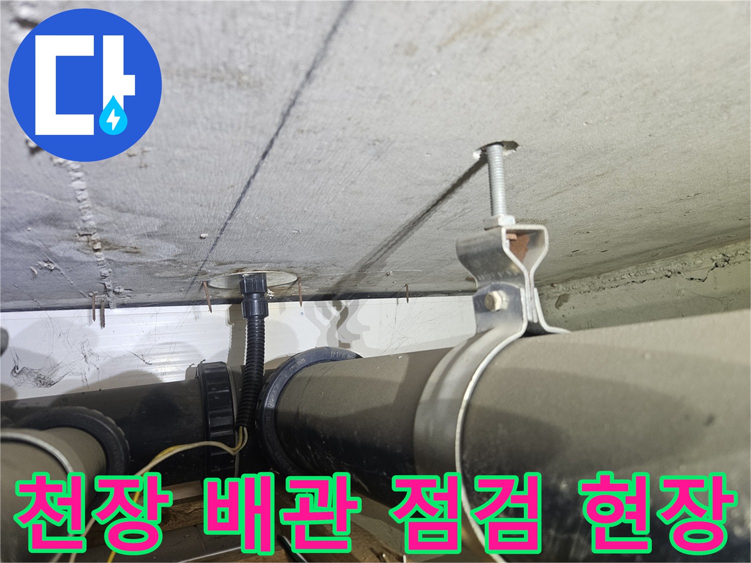 아파트 천장에 설치된 검은색 하수 배관과 고정용 클램프 사진