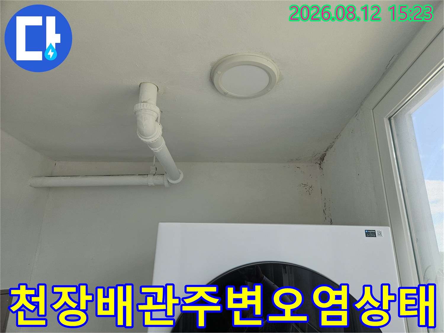 천장의 화이트 배관-벽면 접합부의 어두운 누수 얼룩과 곰팡이