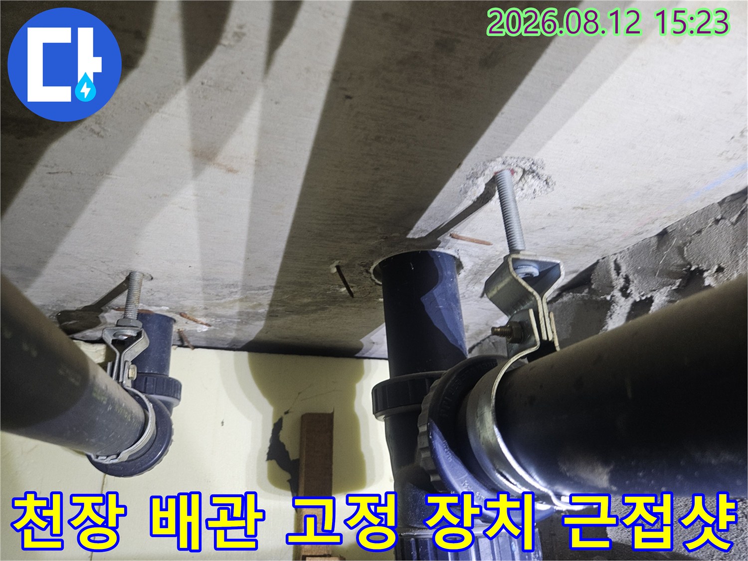 콘크리트 천장에 설치된 검은색 배수관과 이를 지지하는 전산볼트 및 브래킷의 상세 모습