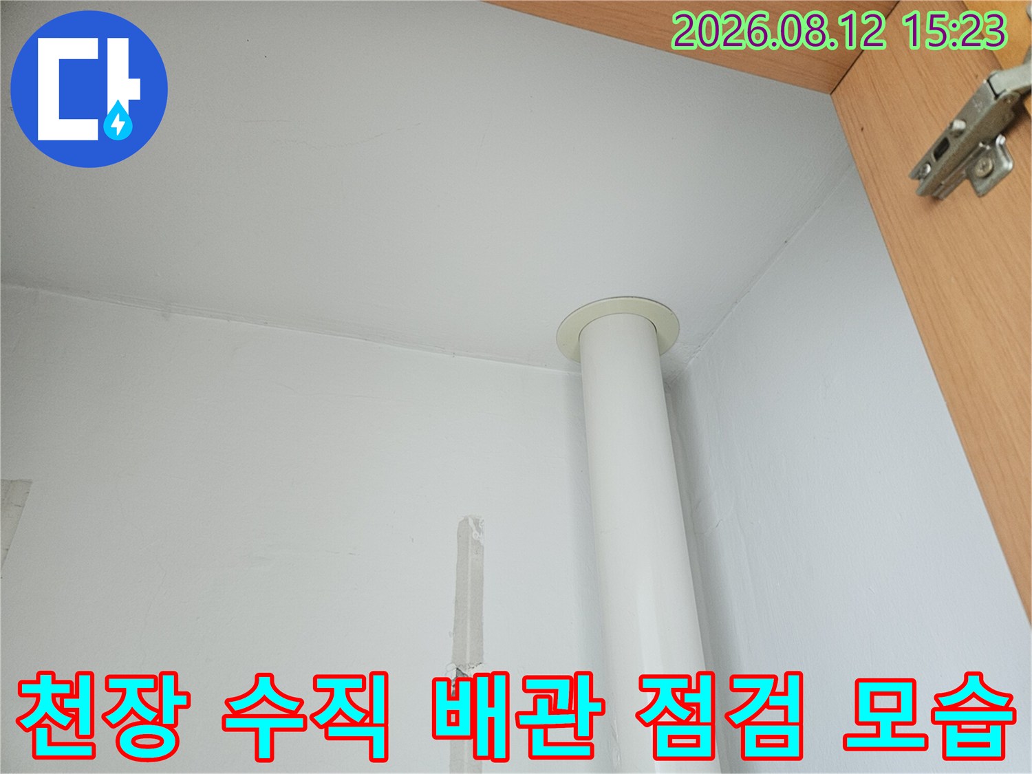 흰색 천장 벽면에 설치된 하얀색 수직 배관과 주변 마감 상태-누수 확인 과정