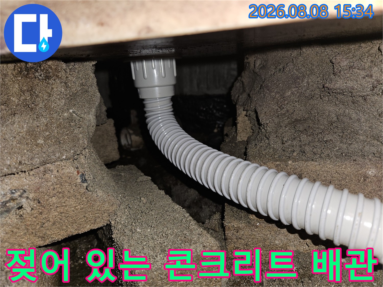 습기를 머금은 듯한 콘크리트 구조물과 하얀색 주름관 배관