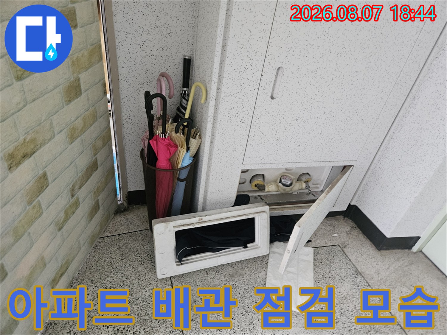 파주 문산 아파트 내부의 수도 계량기함과 노출된 배관 상태를 보여주는 사진입니다.