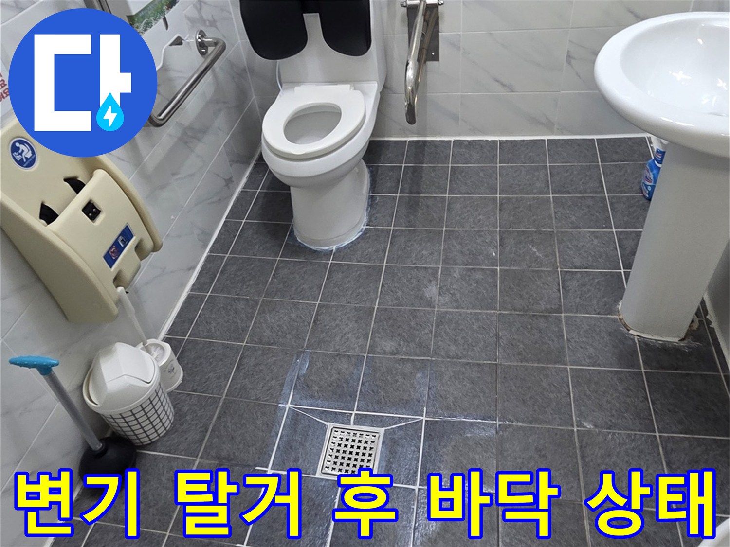 양변기를 제거한 후 드러난 타일 바닥과 배수구 주변의 모습입니다.