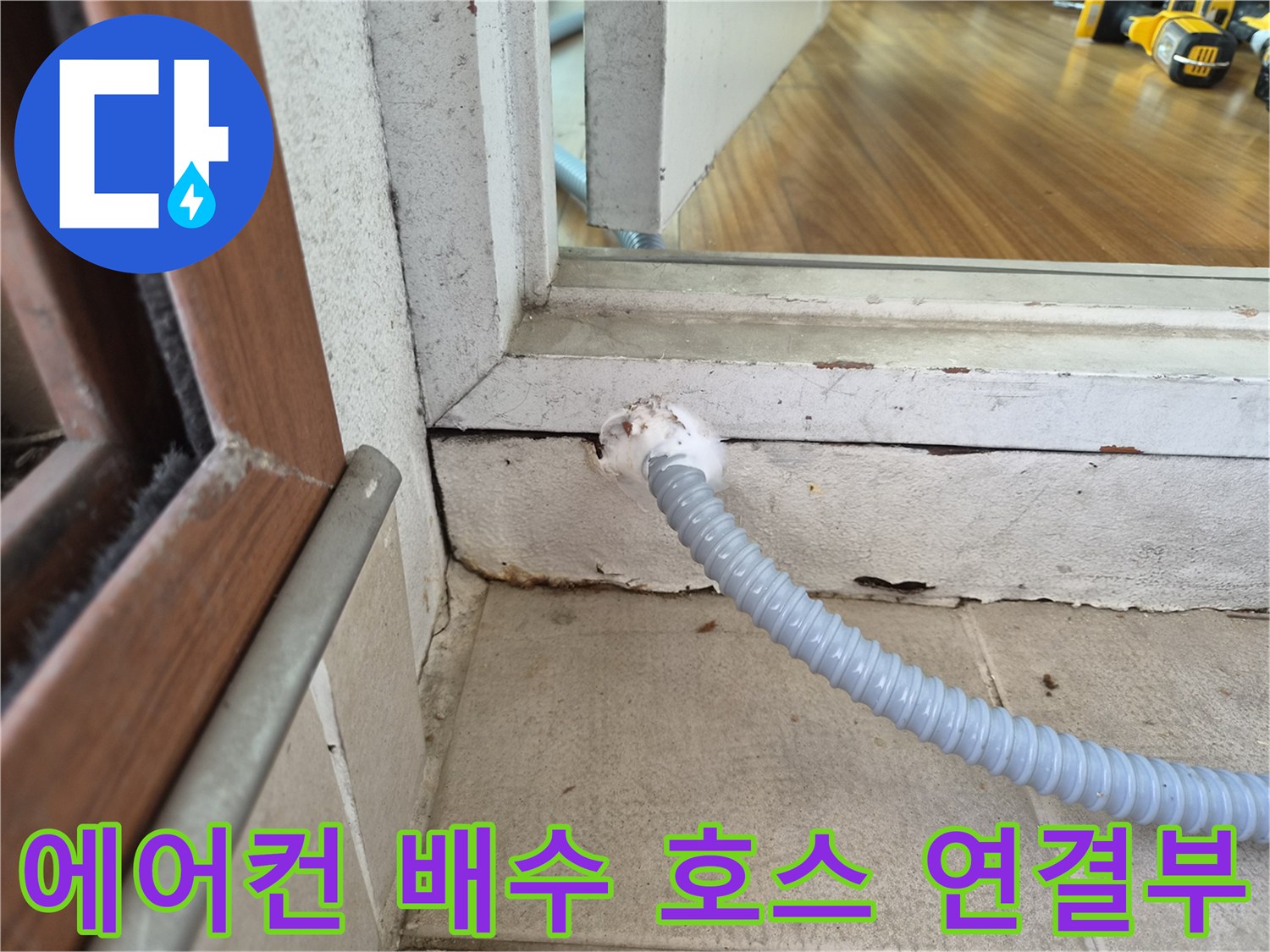 에어–컨 드레인 호스가 벽면 틈새로 연결된 모습입니다.