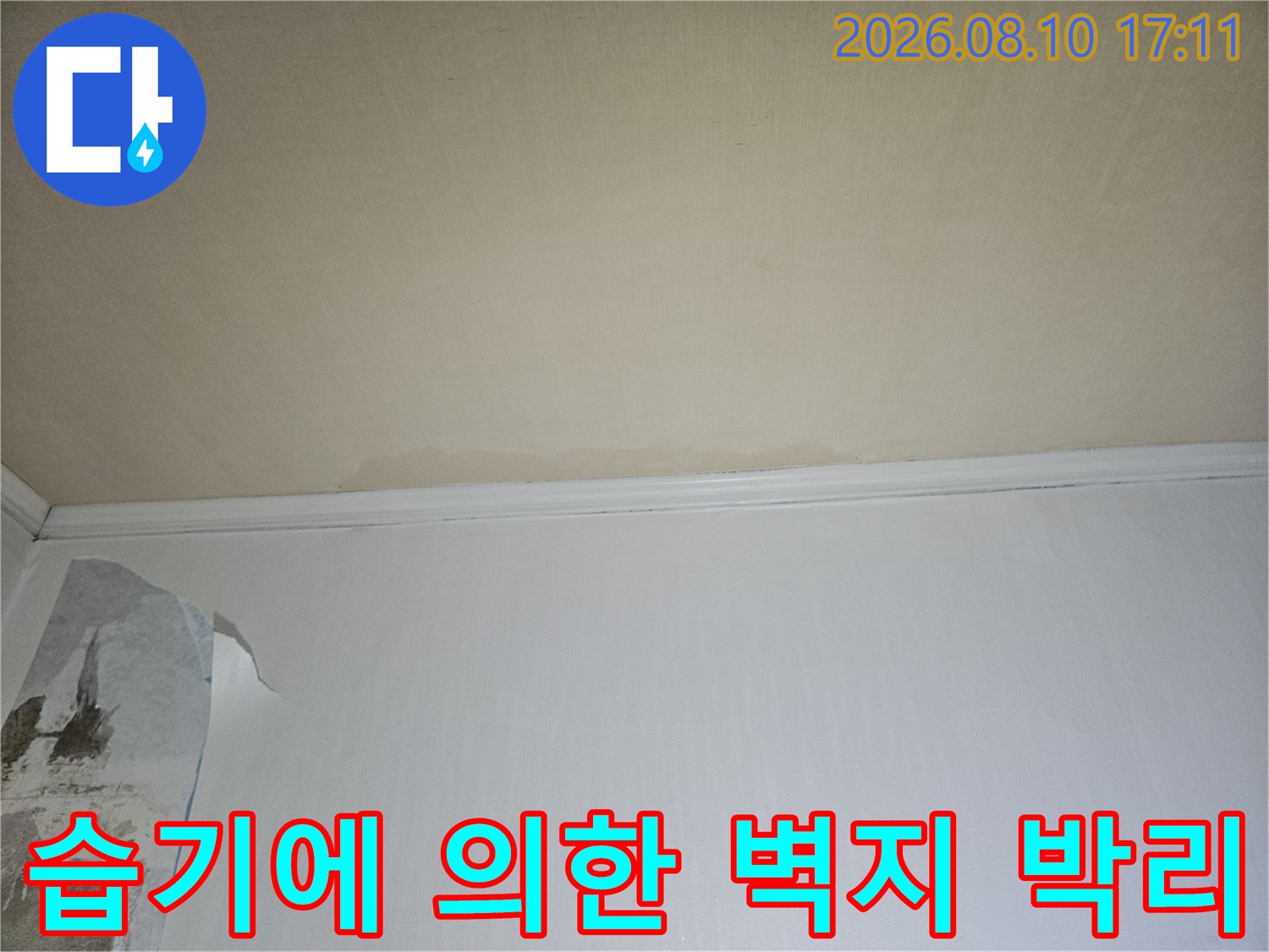 물기가 스며든 벽면-누수로 인해 벗겨지고 변색된 벽지의 모습