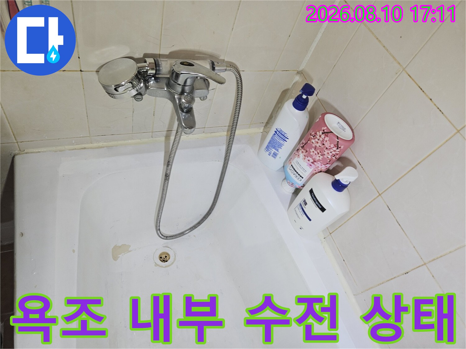 욕조 안쪽의 은색 수전과 샤워 호스 연결 부위 사진입니다.