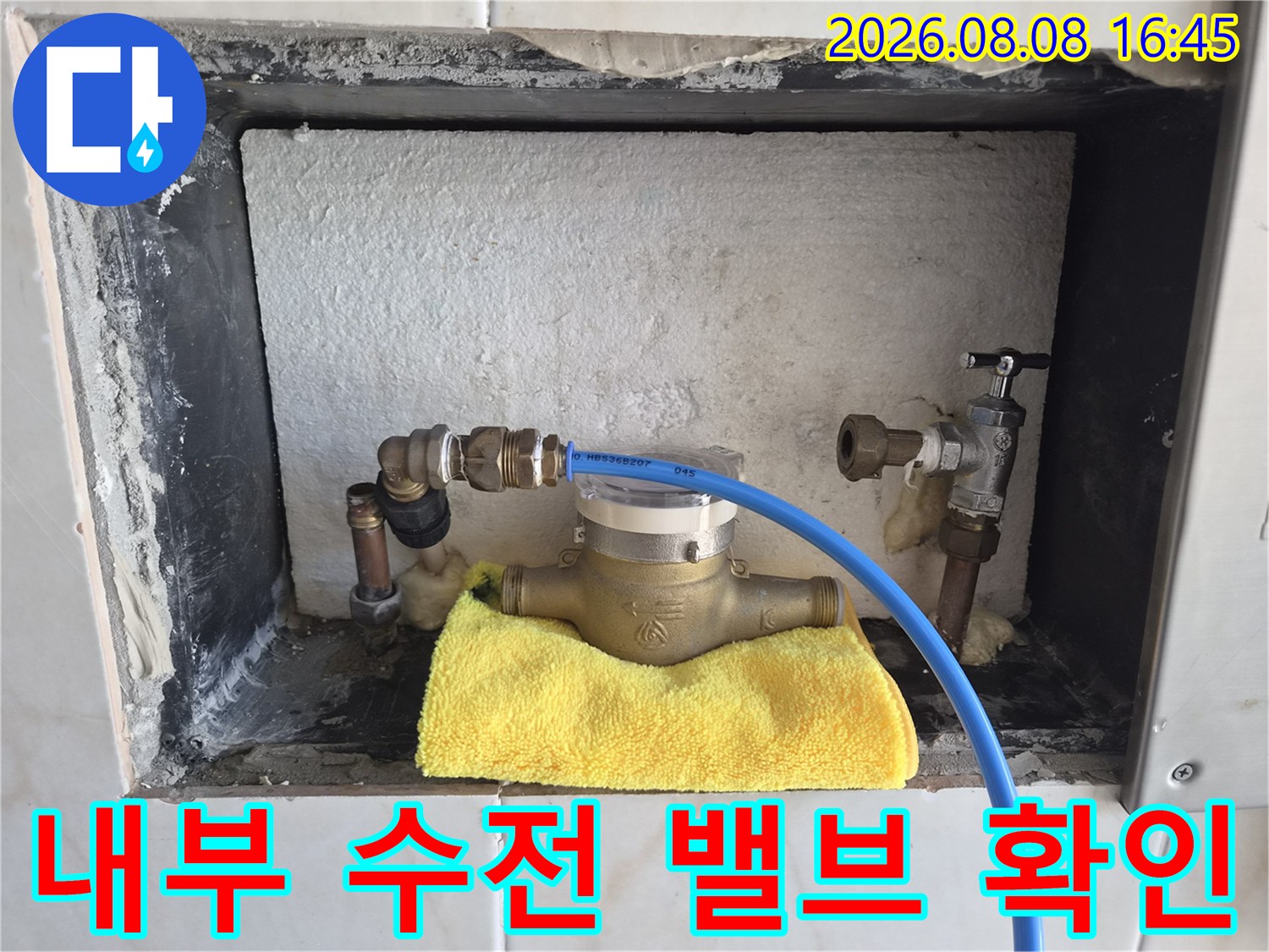 타일을 제거하고 노출시킨 금속 배관과 연결 부위의 모습입니다.