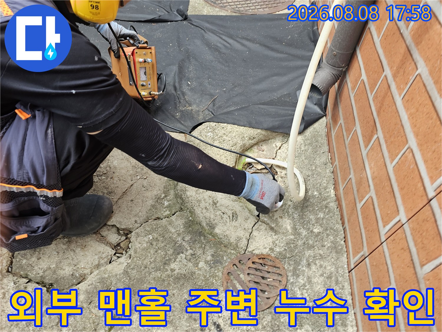 맨홀 인근 콘크리트 균열 부위를 조사하며 누수 지점을 찾는 현장입니다.