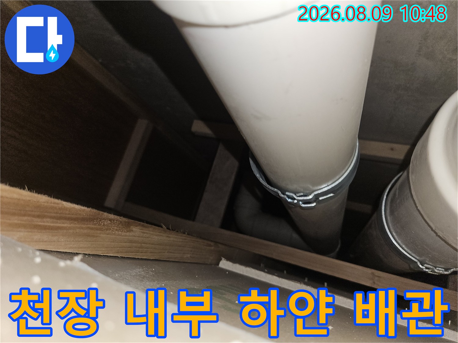 천장 구조물 사이에 배치된 하얀색 배수관의 모습