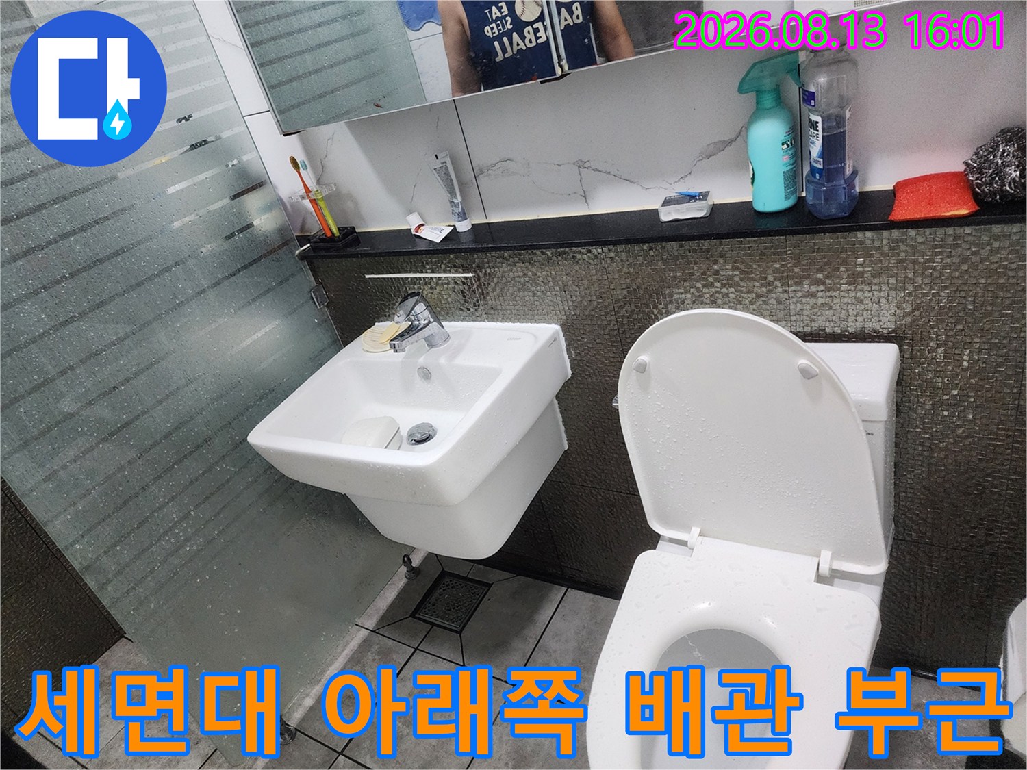벽면에 설치된 세면대와 하단 배관 연결부를 근접하여 촬영했습니다.