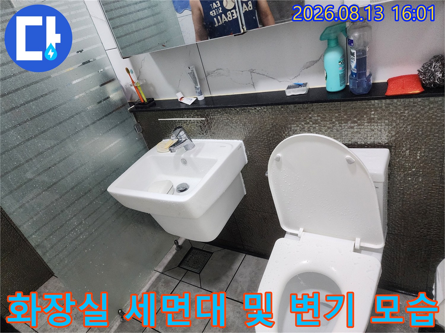 세면대 하단 배관과 양변기가 설치된 욕실 내부 사진입니다.