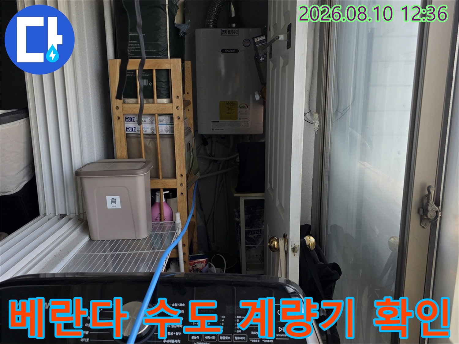 베란다 벽면에 설치된 수도 계량기와 배관 연결 부위의 상세 모습입니다.