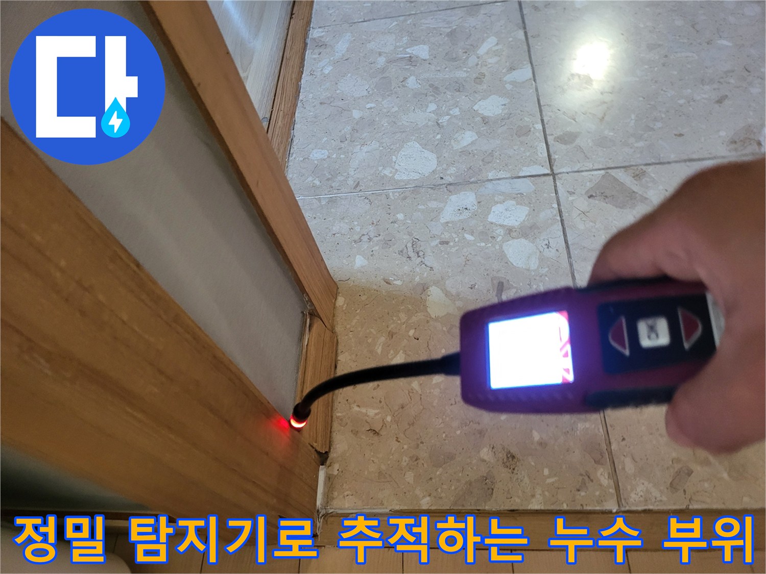 바닥 타일 경계면을 향해 가스 탐지 센서가 위치한 장면