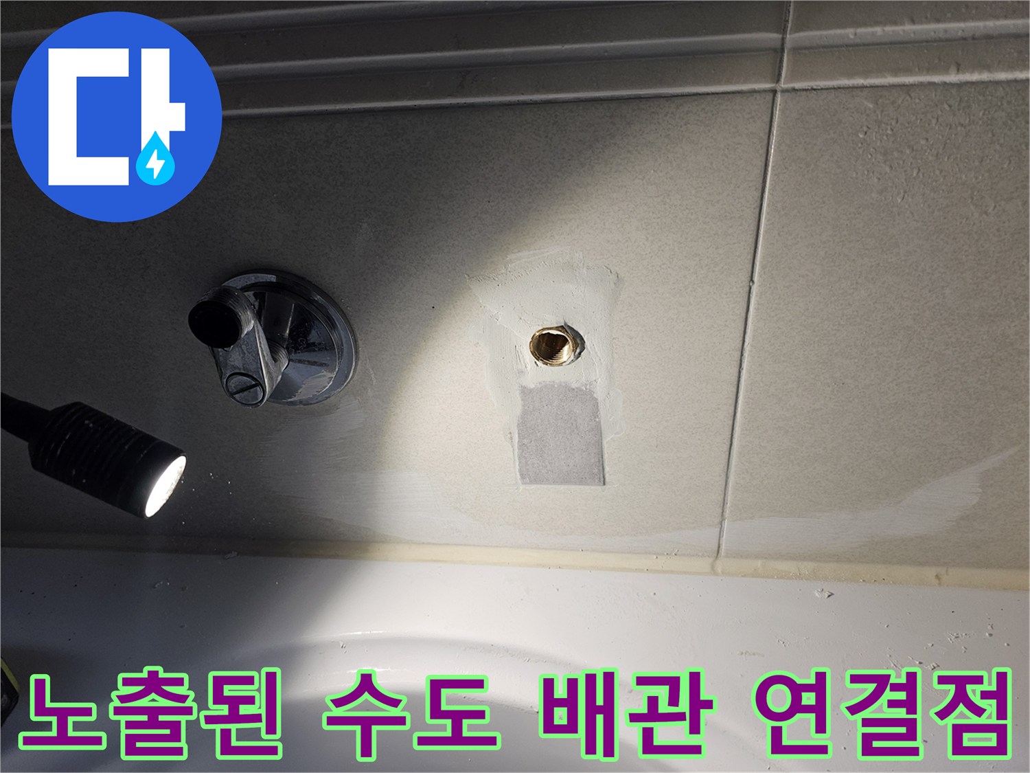 타일 틈새로 드러난 누수가 발생한 배관 연결 지점