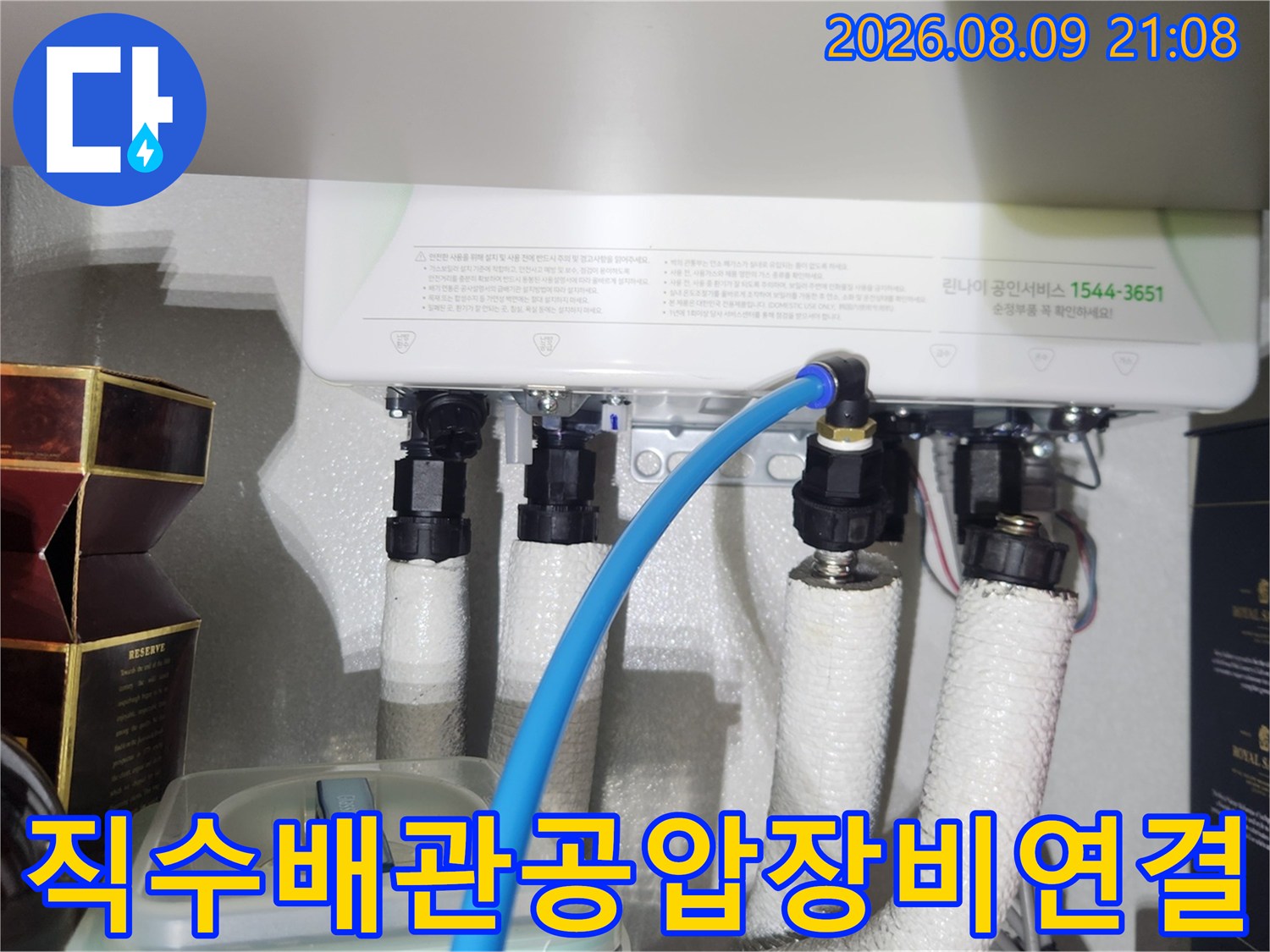 보일러 아래 배관 뭉치에 파란색 공압 검사용 호스가 연결된 사진