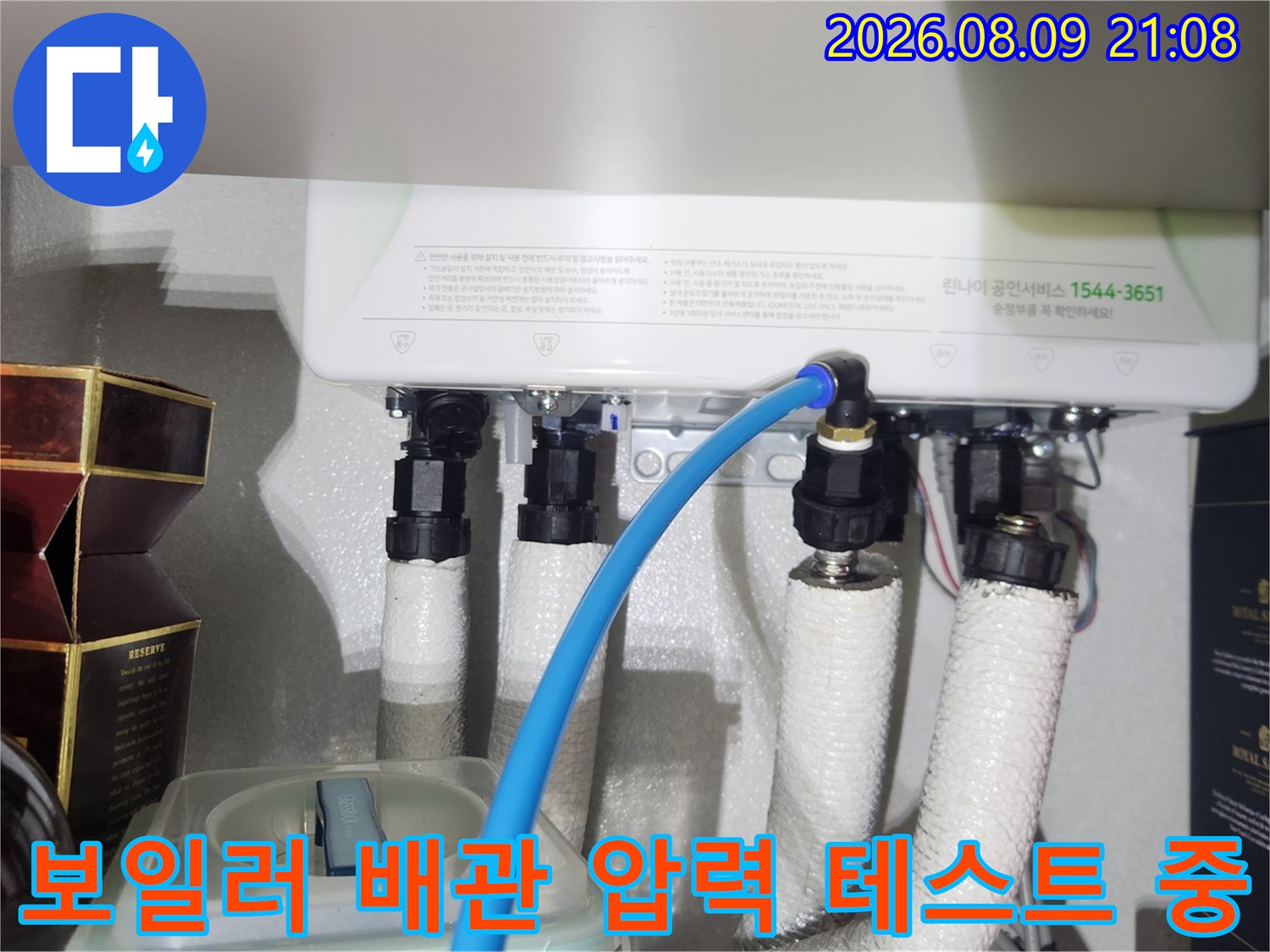 흰색 보온재로 감싸진 배관 연결부에 파란색 공압 호스가 체결된 모습