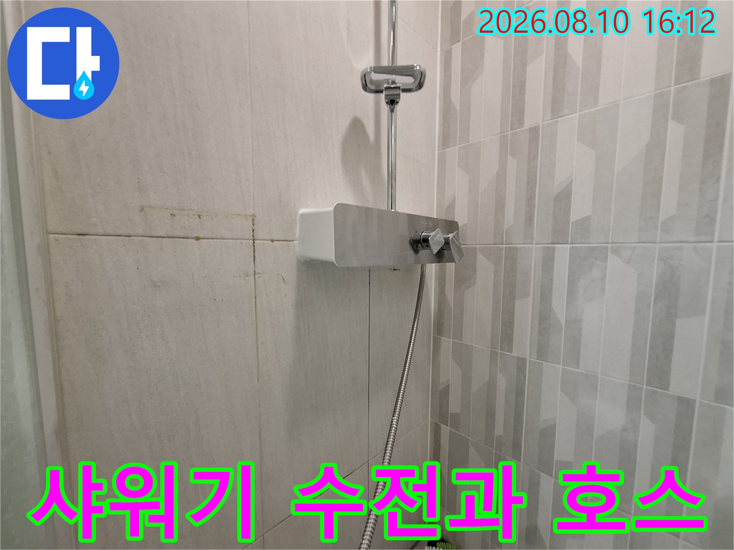 욕실 벽면에 설치된 샤워기 헤드와 연결 호스 근접 촬영