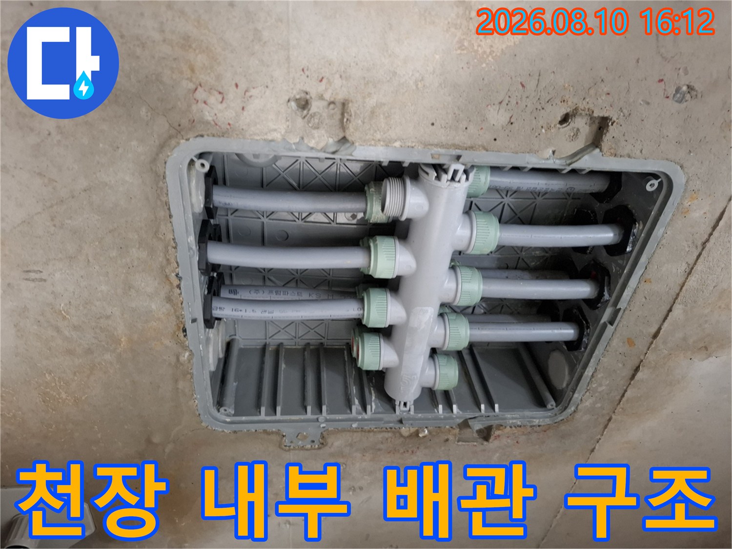 화장실 천장 점검구 내부에 노출된 수전 분배기 및 연결 배관