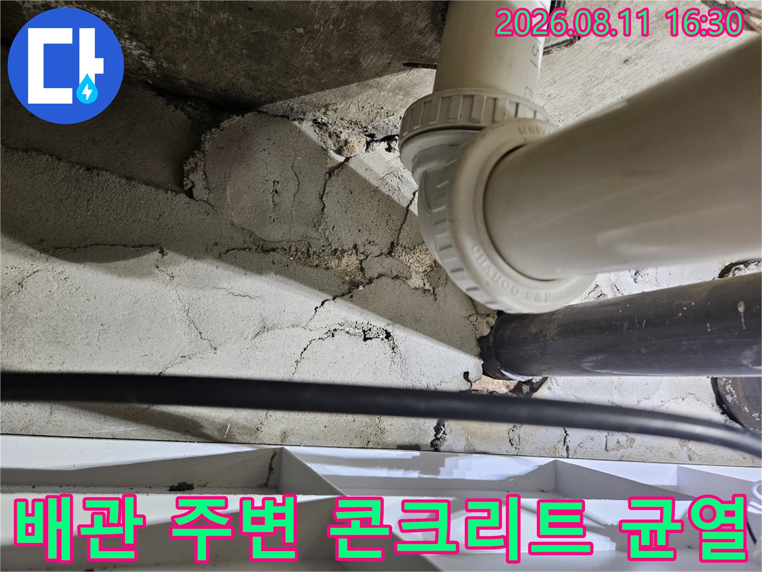 천장 내부 배관 주변의 갈라진 틈새와 습기를 보여주는 사진입니다.