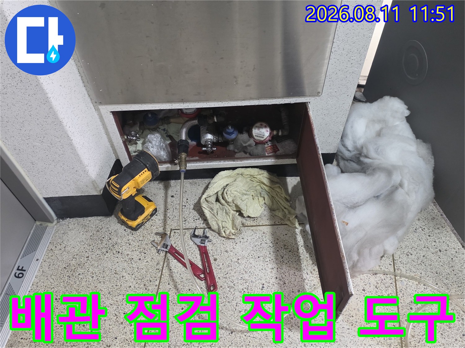 현장에서 사용 중인 배관 점검용 렌치와 전동 드릴의 모습