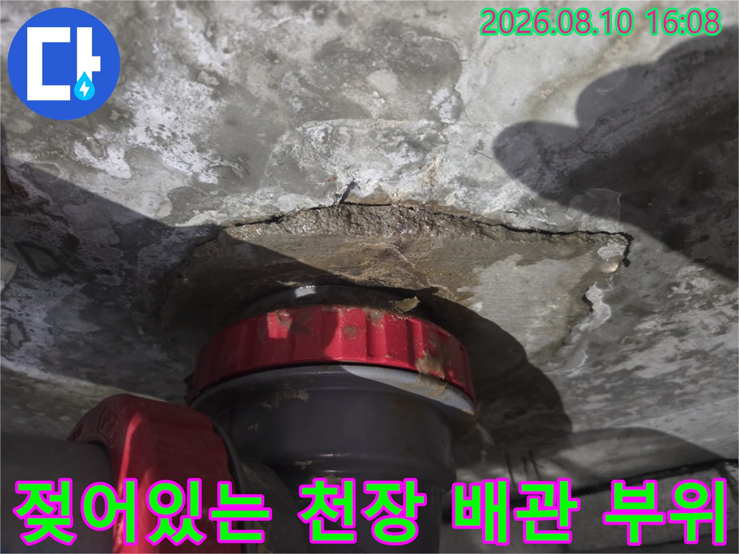 배관 주변 콘크리트 면에 나타난 습기 침투와 얼룩진 모습입니다.