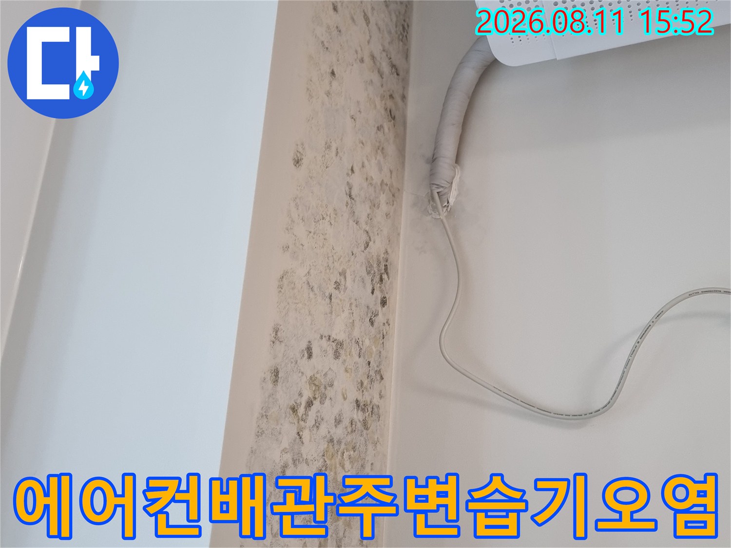 흰색 벽면에 퍼진 갈색 곰팡이 자국과 에어컨 드레인 호스가 연결된 부분의 모습