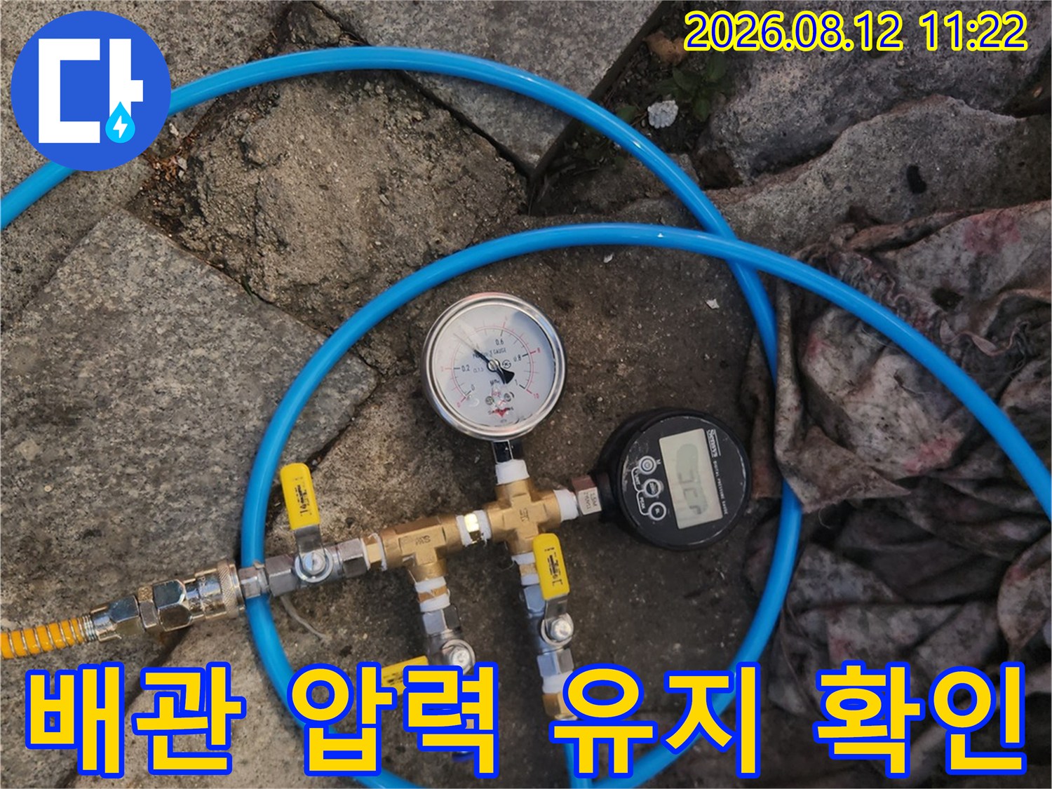 파란색 호스와 압력계가 연결된 배관 점검 장비 모습
