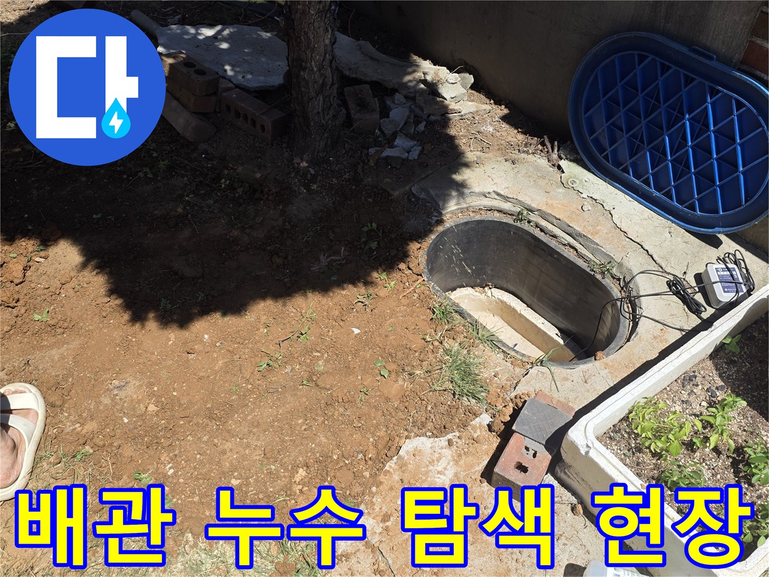 맨홀 주변의 젖은 지면과 가스 탐지 장비가 놓인 작업 현장