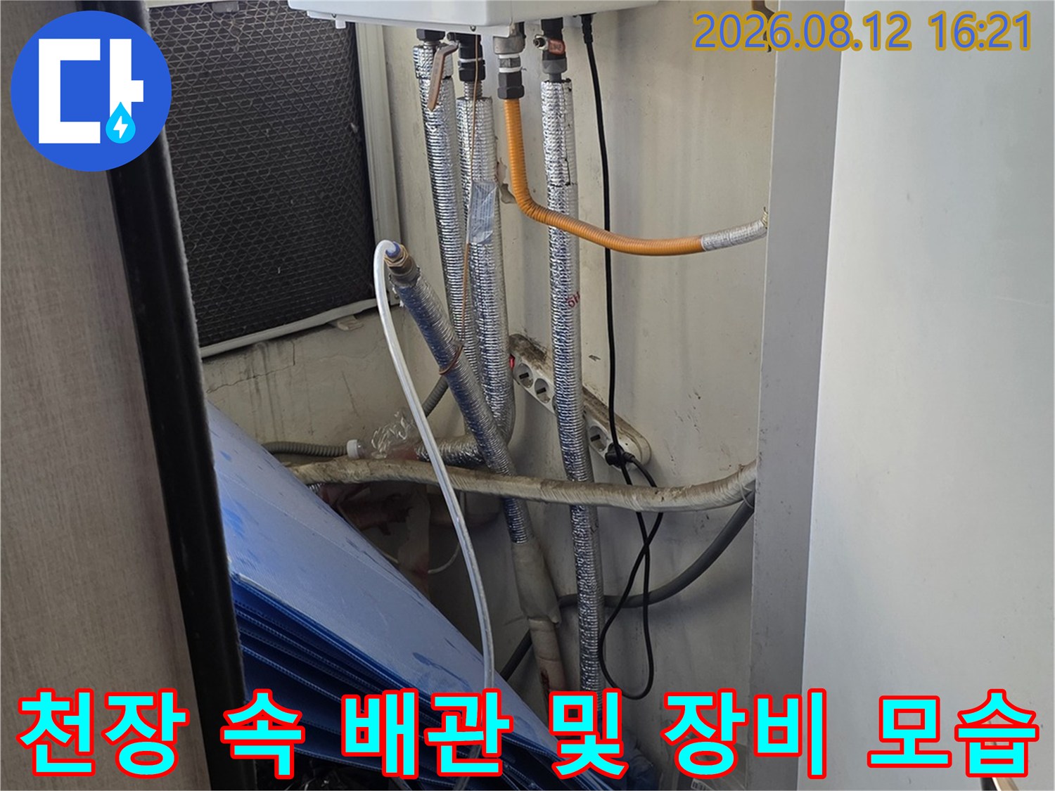 좁은-천장-공간-내부에-설치된-흰색-기기와-금속-자바라-호스의-연결-상태