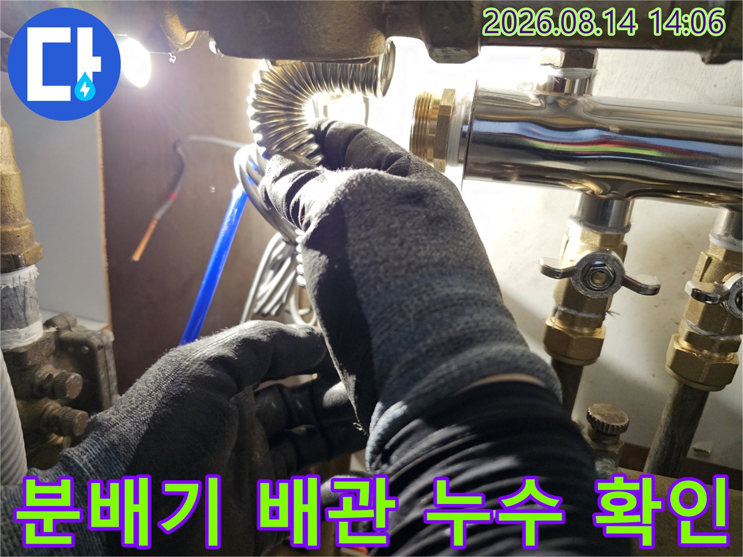 분배기 밸브와 주름관의 연결 부위를 점검하는 현장 사진입니다.