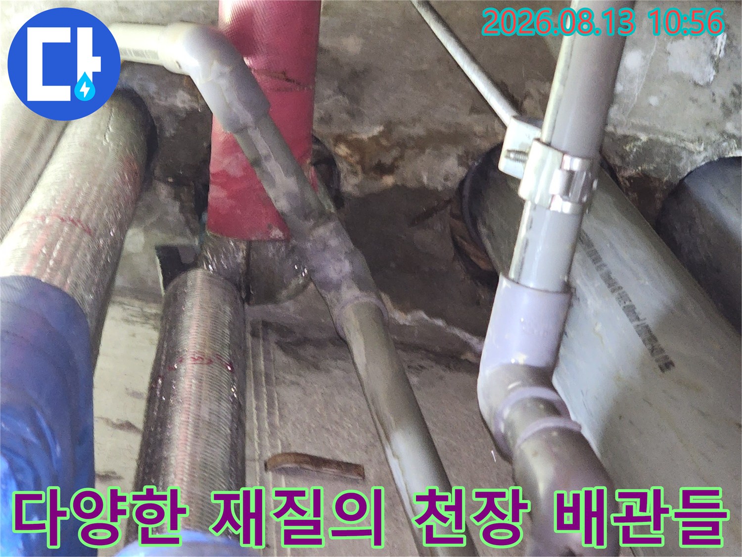 회색 피브이씨 관과 붉은색 배관 그리고 파란색 보온재가 씌워진 배관들이 교차된 사진