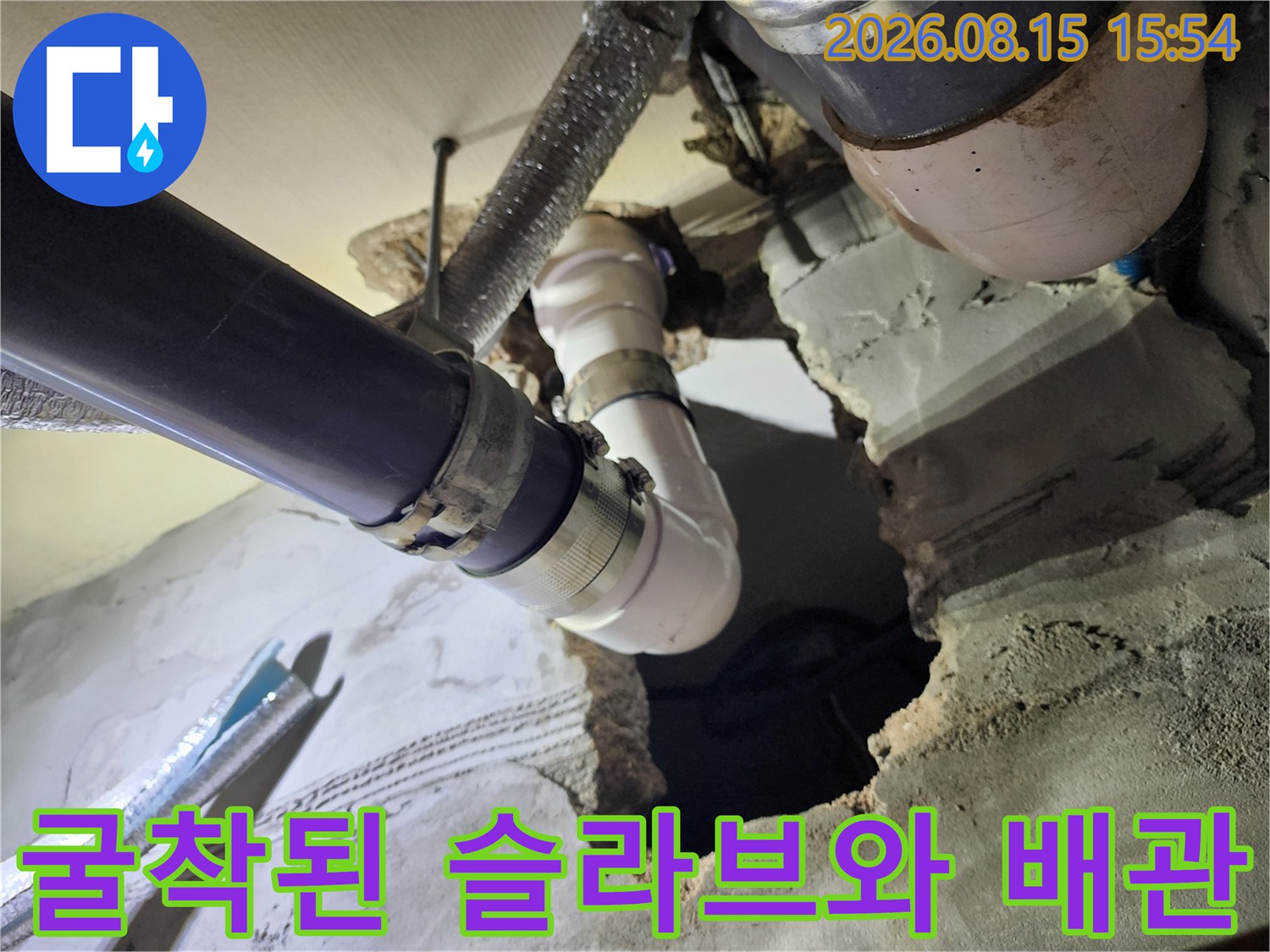 콘크리트 굴착 부위 사이로 드러난 흰색 오수 배관과 보온재 처리된 관