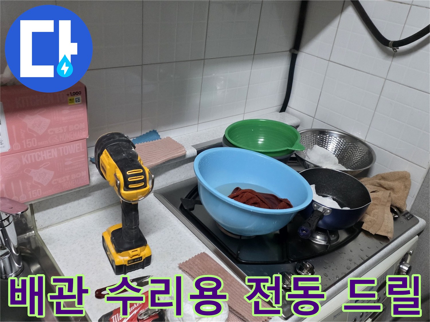 누수 지점의 배관 교체를 위해 준비된 전동 공구와 주방 환경