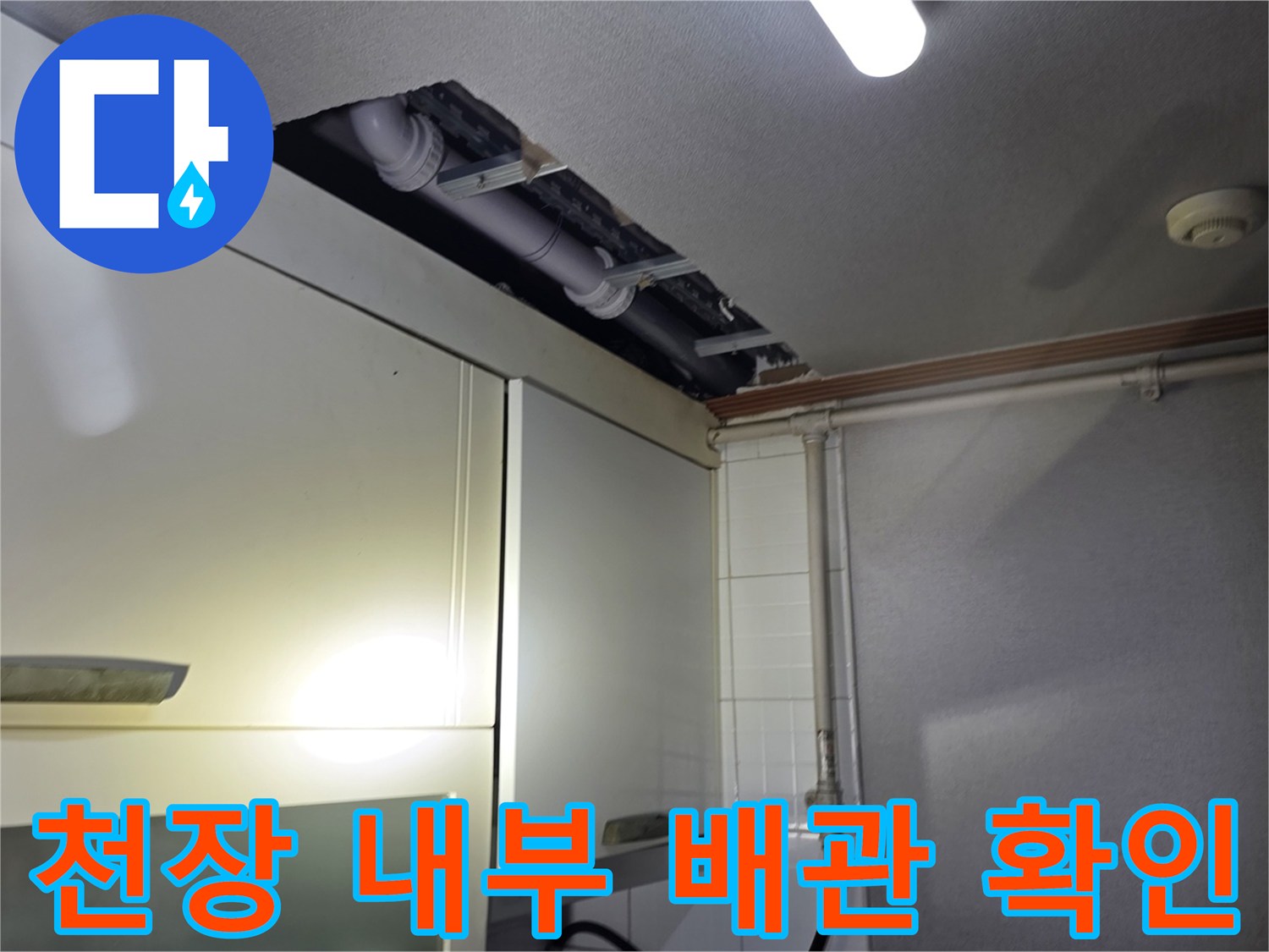 싱크대 상단 틈새로 보이는 노출된 배관과 천장 구조