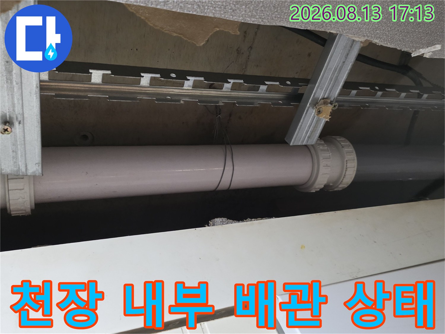 천장 안쪽 금속 지지대에 설치된 하수 배관의 외관