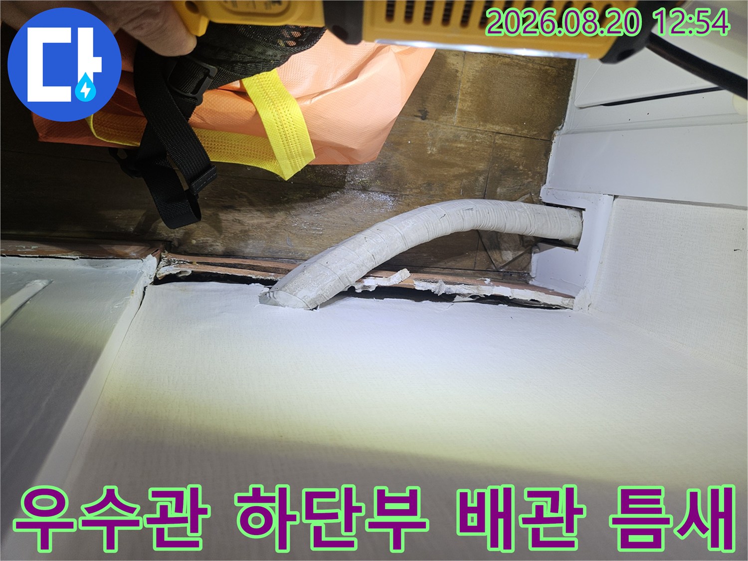 우수관 배관 주변의 마감재 균열과 벌어진 틈을 포착한 사진입니다.