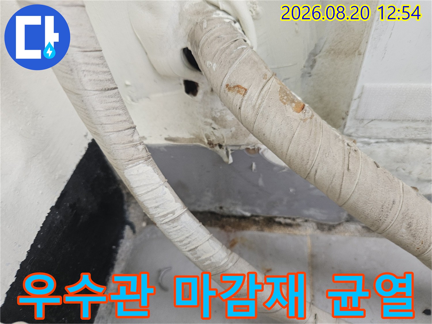 우수관 주변의 갈라진 벽면 마감재와 틈새