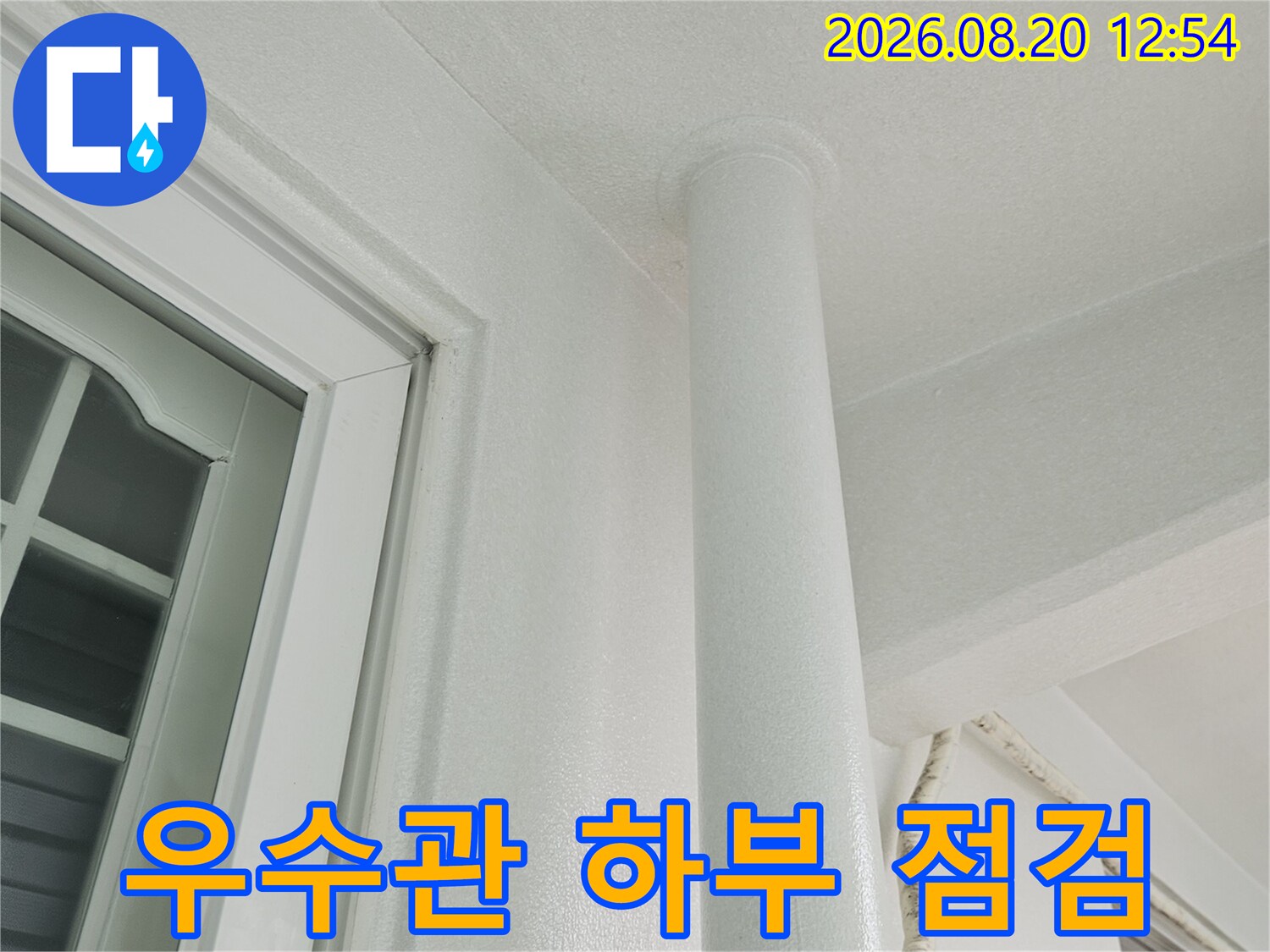 천장에 고정된 우수관 배관과 창문 상단 프레임의 사진입니다