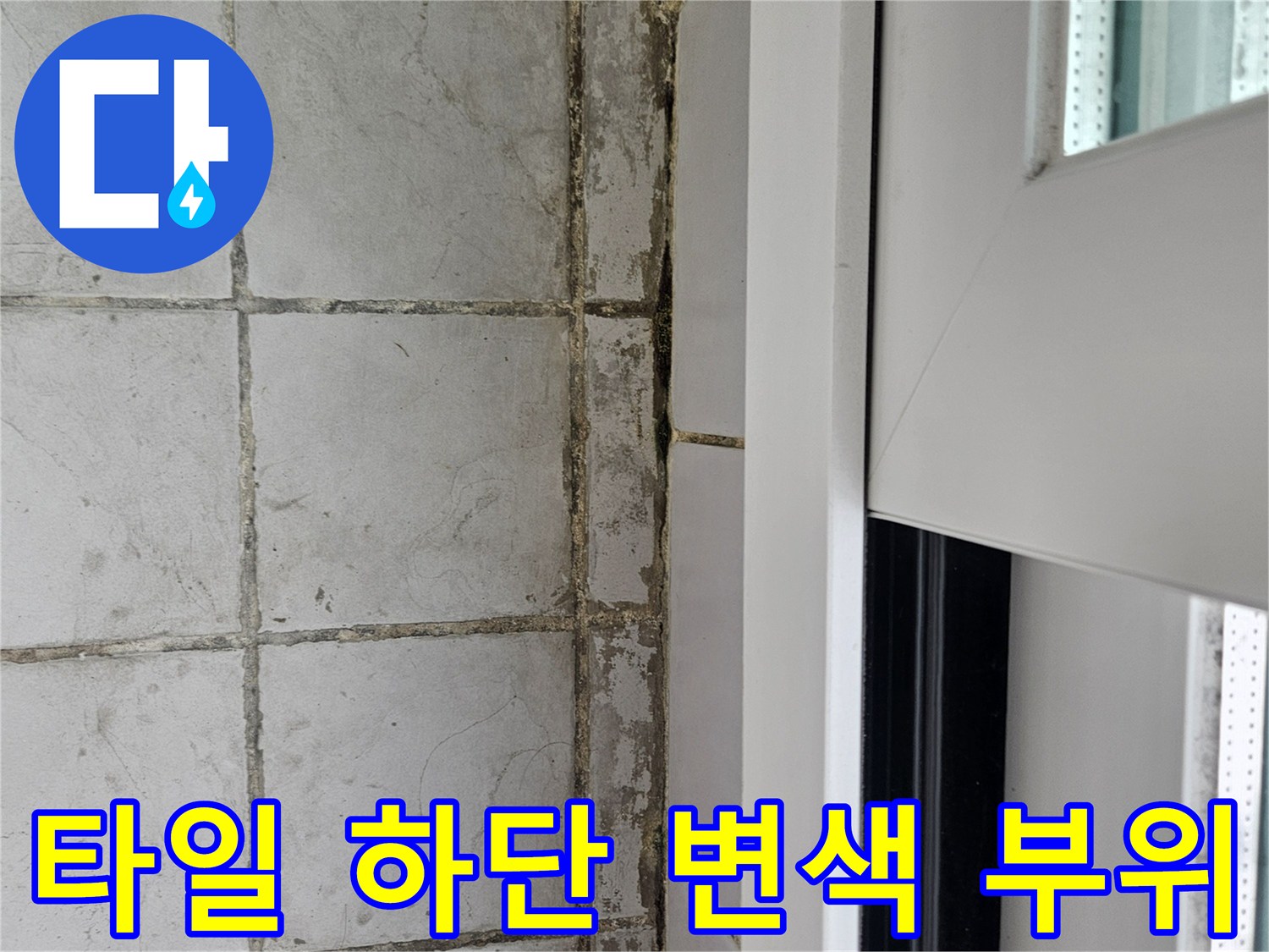 타일 하단부의 어두운 얼룩과 균열 상태를 근접 촬영한 이미지입니다.