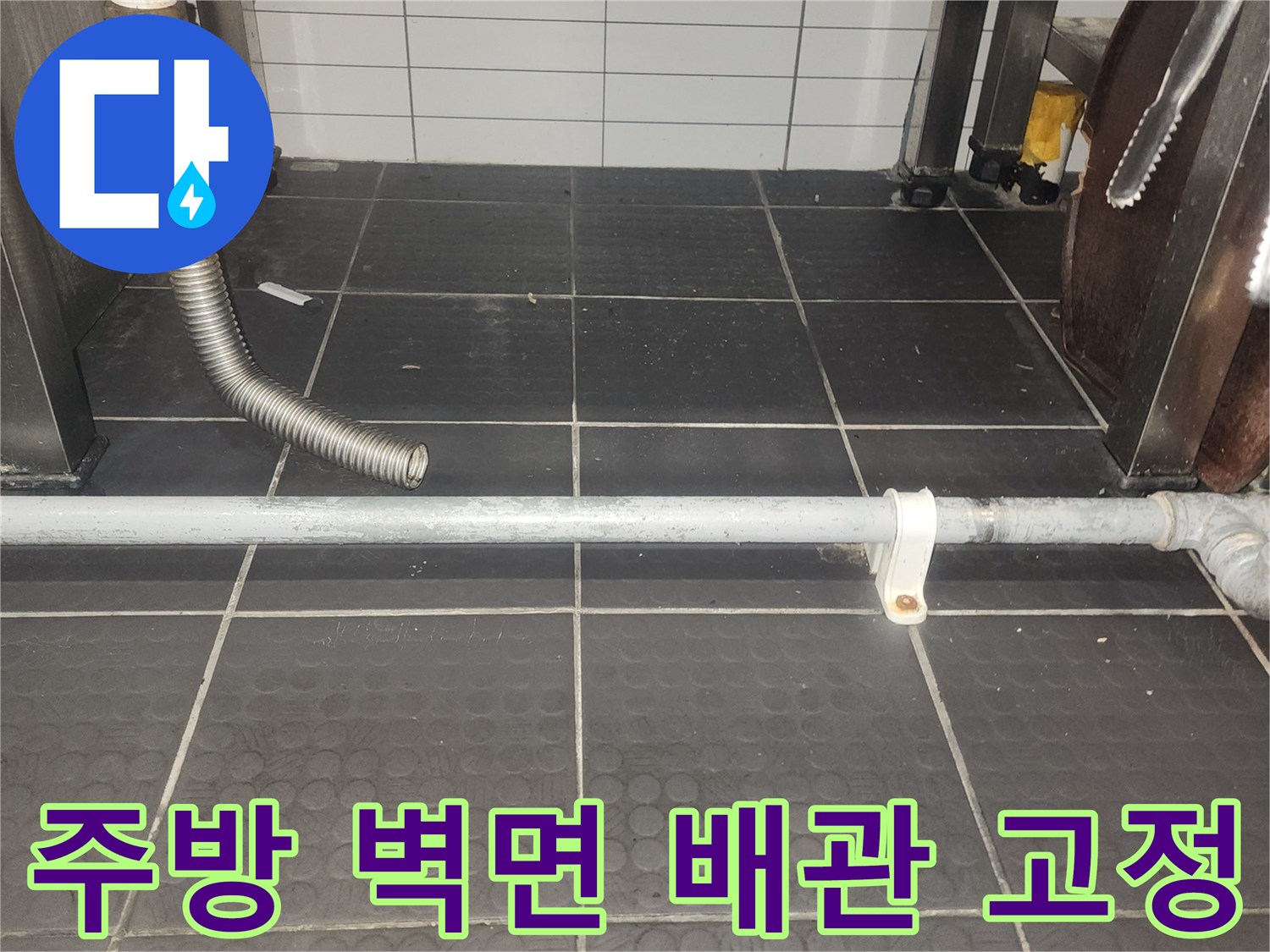 벽면에 고정된 배관 브래킷과 타일 마감 상태를 촬영한 사진입니다.
