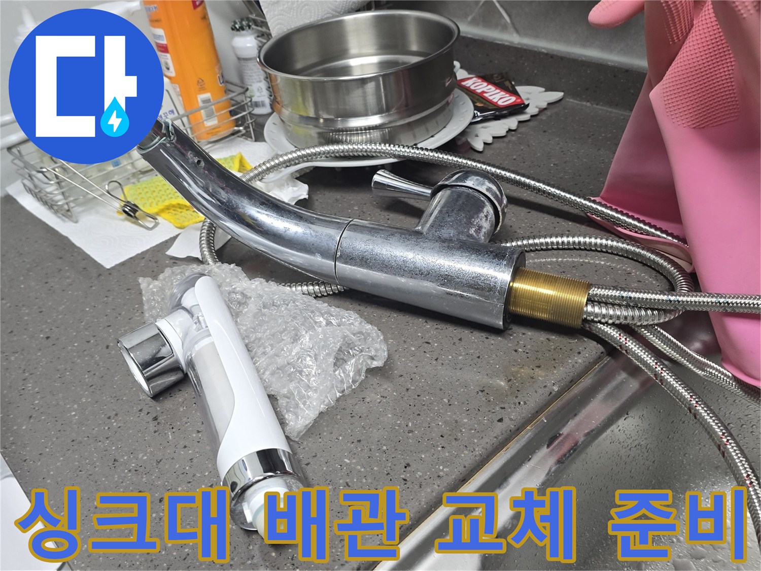 싱크대-하부장-내부의-노후된-수전과-새로운-교체용-자재