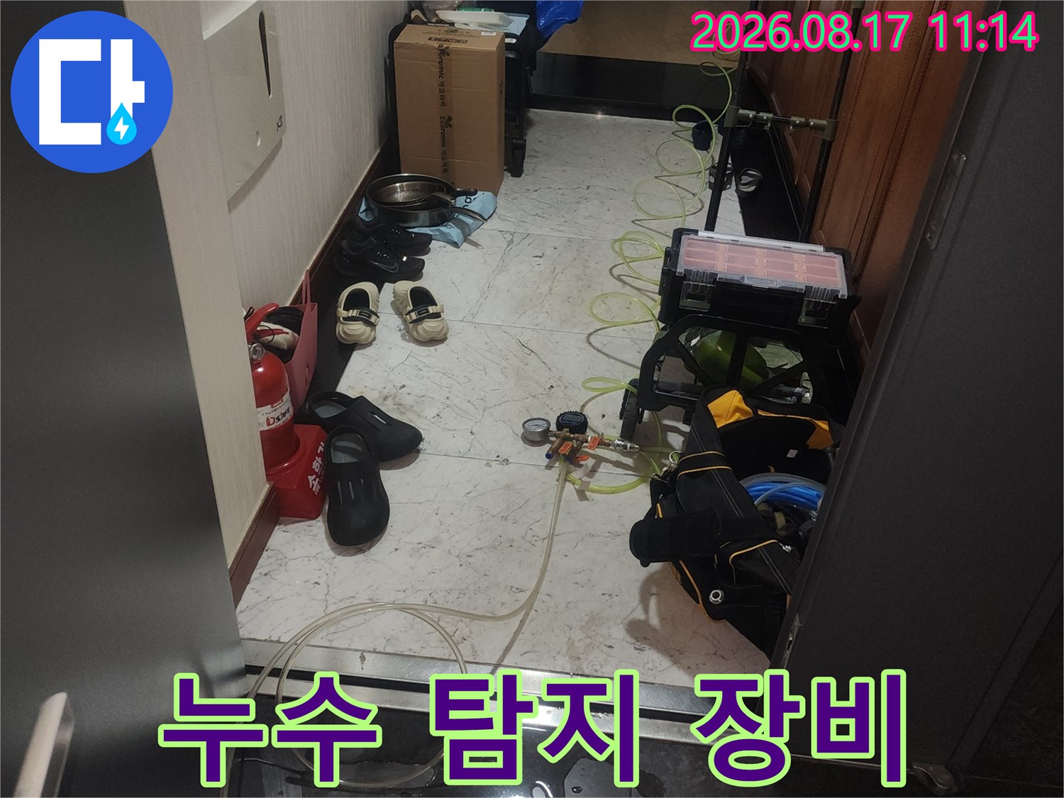 싱크대 하단 공간에 배치된 누수 진단을 위한 전문 측정 기구들