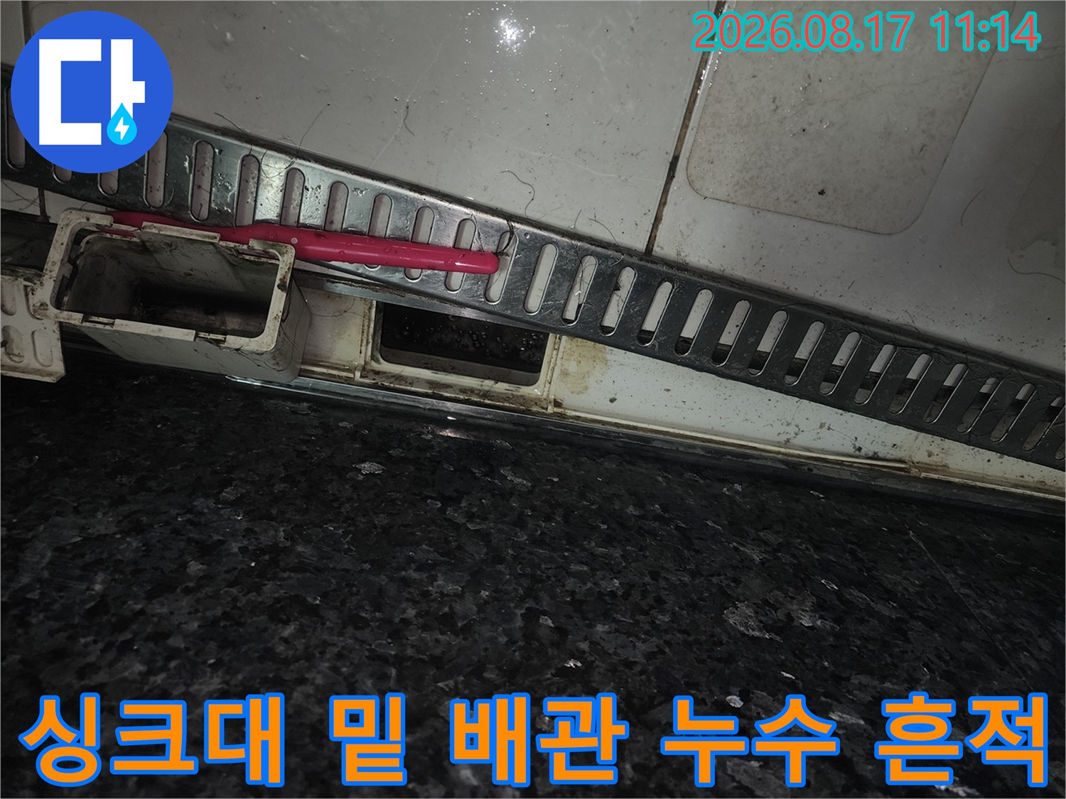 싱크대 하부 타일 틈새와 배관 주변의 습한 상태를 촬영했습니다.