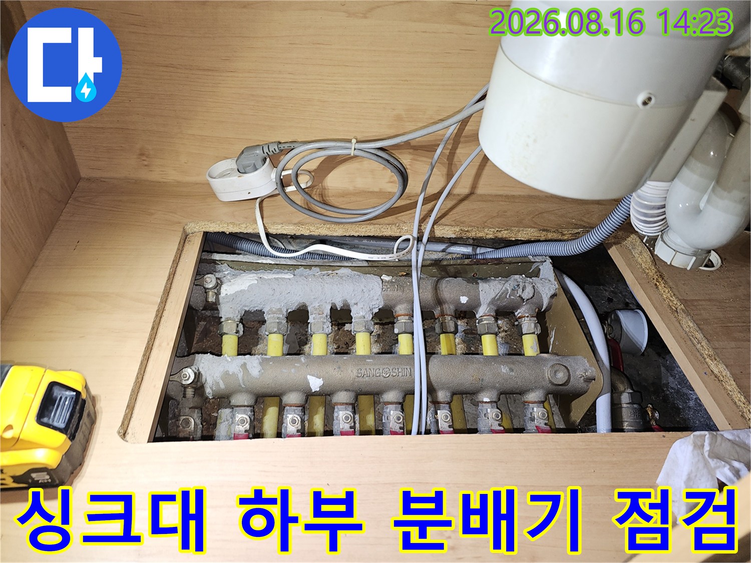 도봉구 싱크대 하부장 내부의 보일러 분배기와 연결 배관 상태를 정밀하게 점검하는 모습입니다.