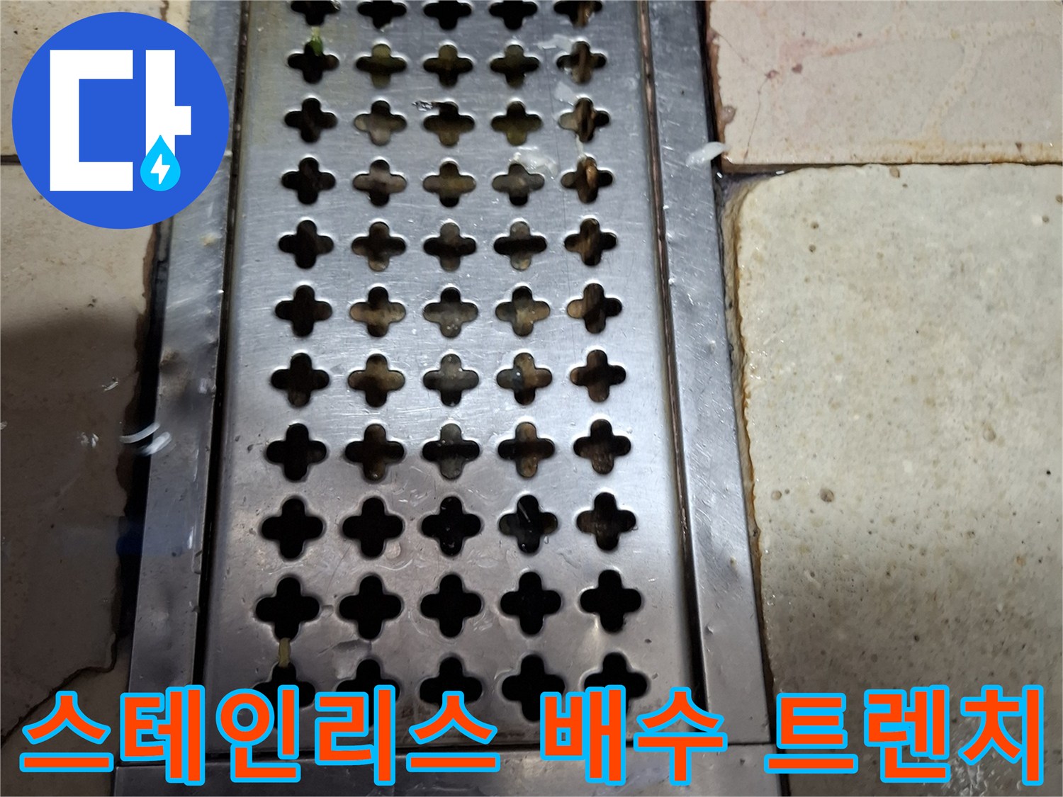 식당 내부 스테인리스 재질의 배수구 덮개와 타일 마감 상태