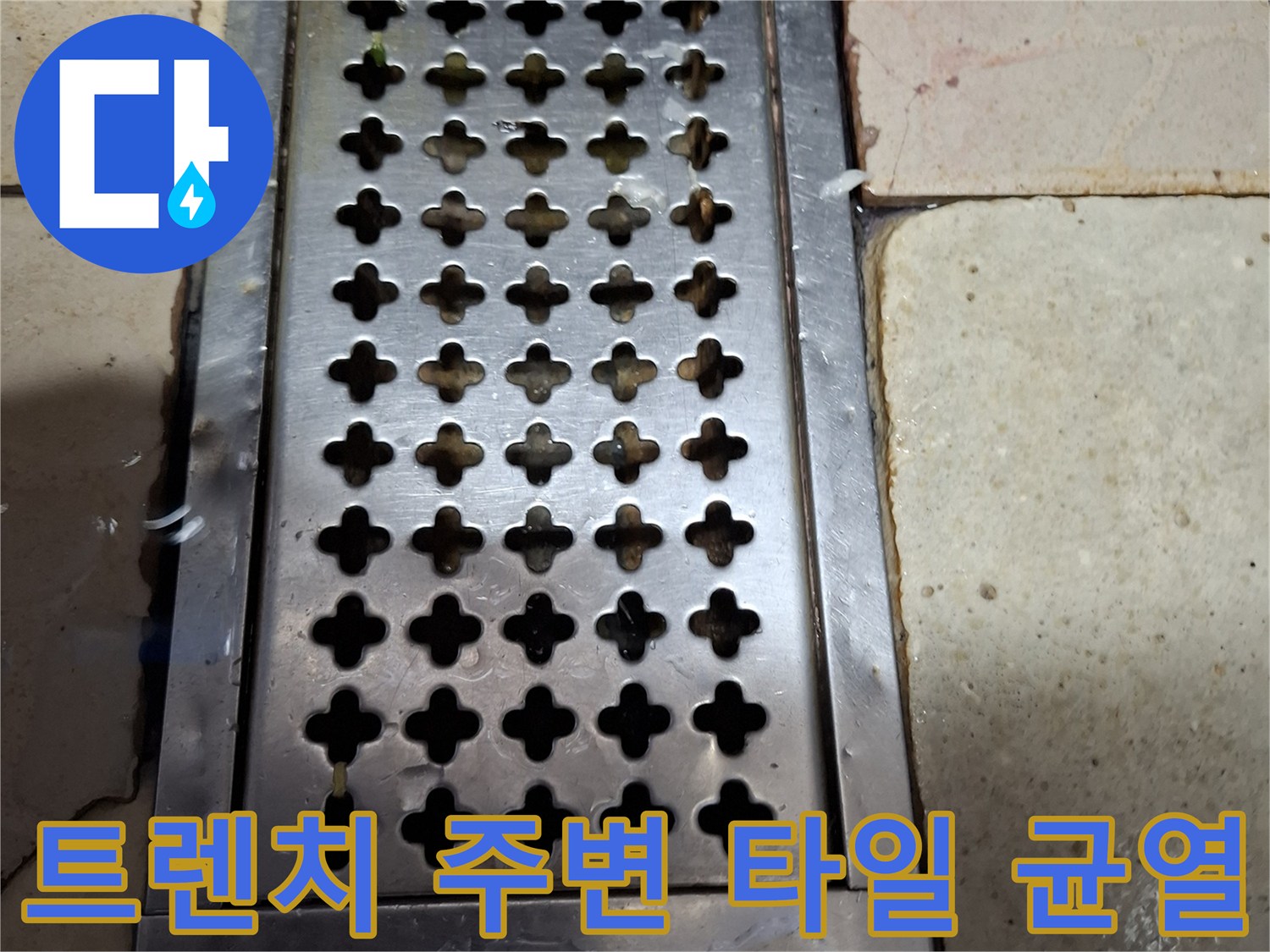 식당 배수구 금속 트렌치와 노후된 타일 사이의 틈새 모습